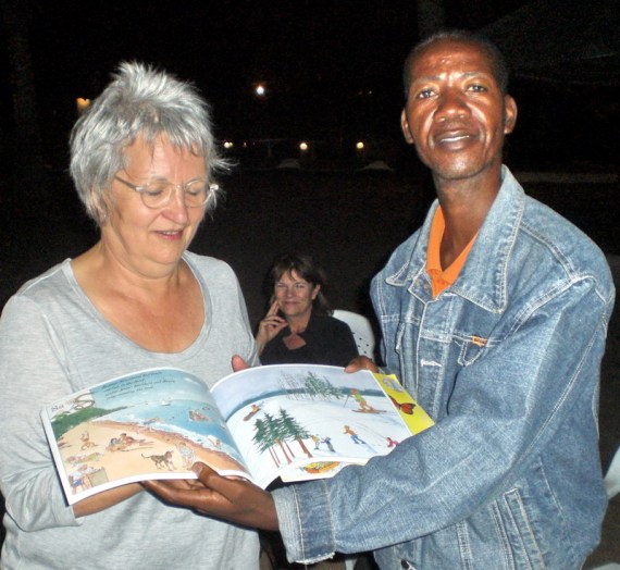 MaryJo gives Madeleine Island book to Charles Tepero near Mangochi, Malawi